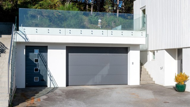 Frittstående garasje fra 2014 oppført i mur og betong, med gresstak, leddport og innlagt strøm.