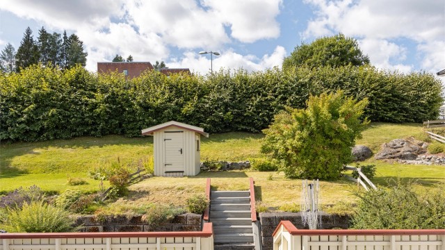 Eiendommen har en lettstelt hage og bod for ekstra lagring.