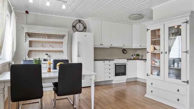 Kjøkkeninnredningen fra 2005 har lyse, slette fronter og laminat benkeplate.