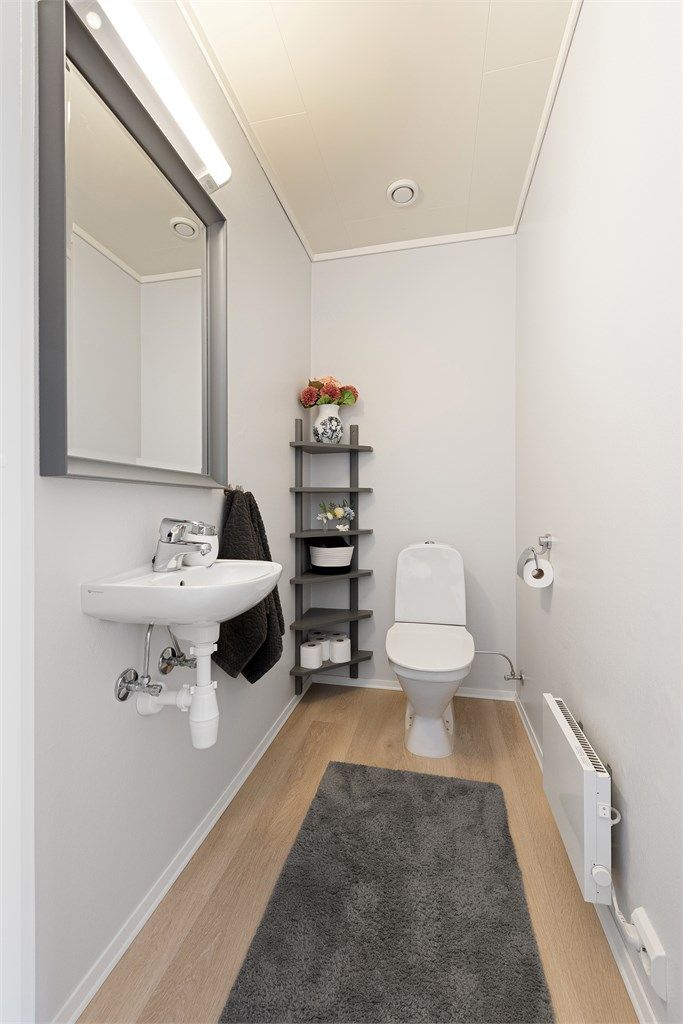 Praktisk toalettrom i andre etasje, innredet med vegghengt servant og gulvstående toalett.