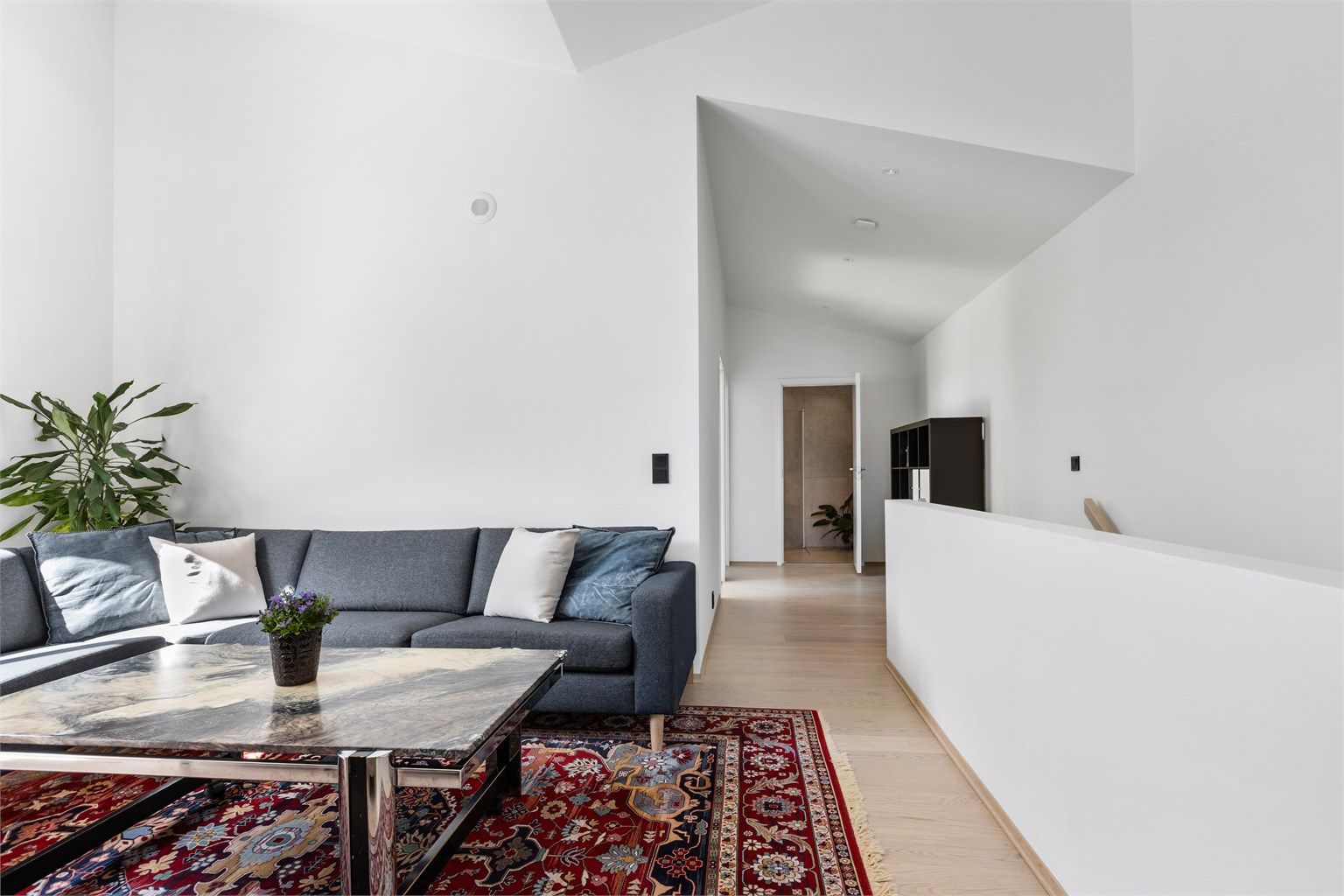 Skråtaket og de rene flatene skaper en spennende arkitektur i rommet.