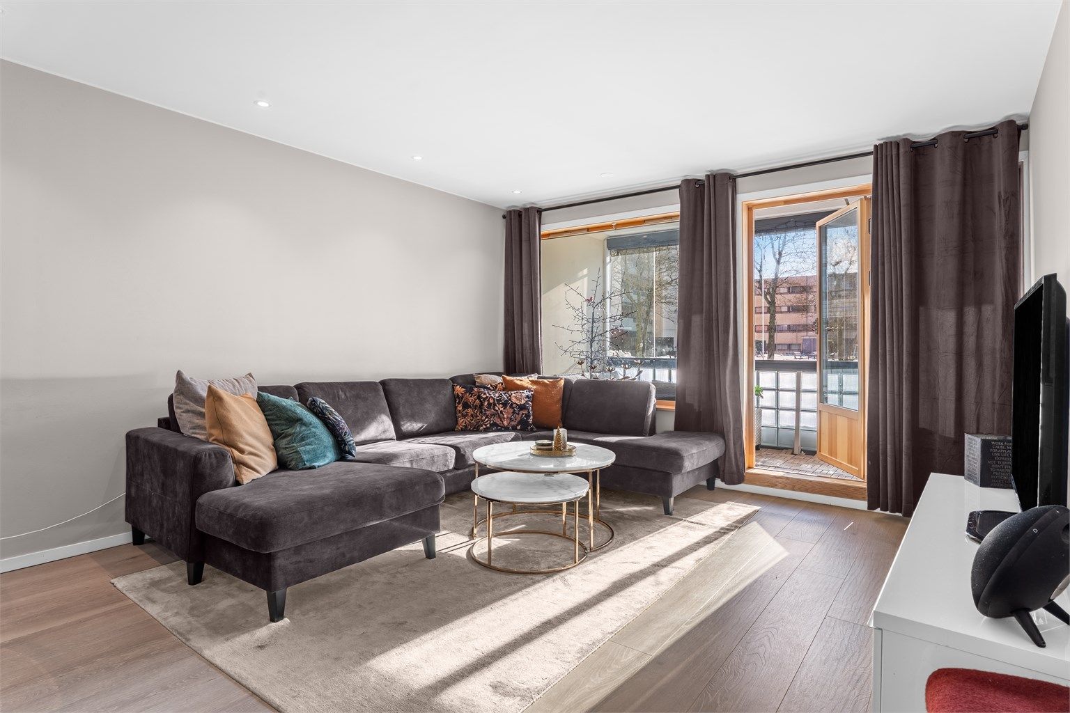 De store vinduene gir godt med lys. Her er det også utgang til sydvendt innglasset balkong.