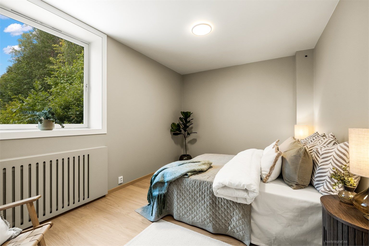 Romslig hovedsoverom med parkett på gulv og oppvarming via radiator.