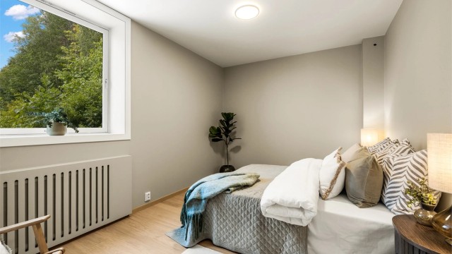 Romslig hovedsoverom med parkett på gulv og oppvarming via radiator.