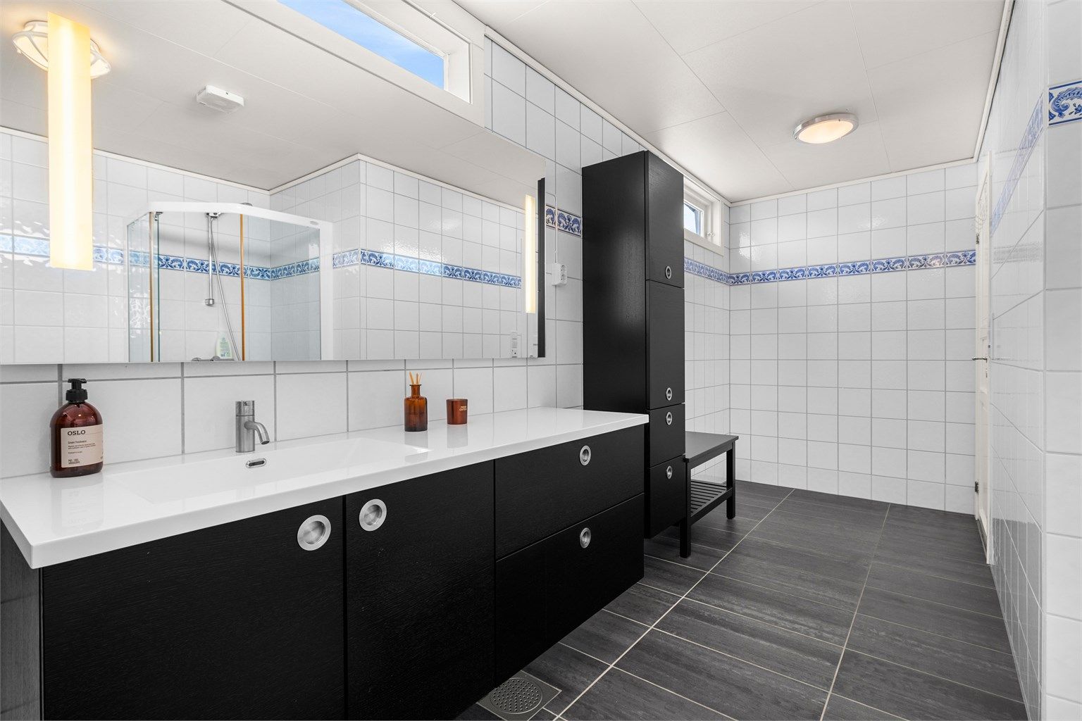 Flislagt bad med gulvvarme og praktisk servantinnredning fra 2013. Rommet har en funksjonell utforming som gir god flyt i hverdagen.