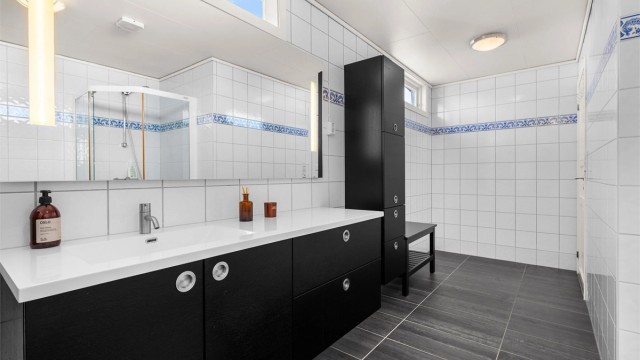 Flislagt bad med gulvvarme og praktisk servantinnredning fra 2013. Rommet har en funksjonell utforming som gir god flyt i hverdagen.