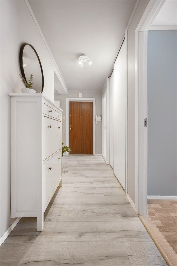 Man kommer inn i en innbydende entré med laminat på gulv og lysmalte vegger