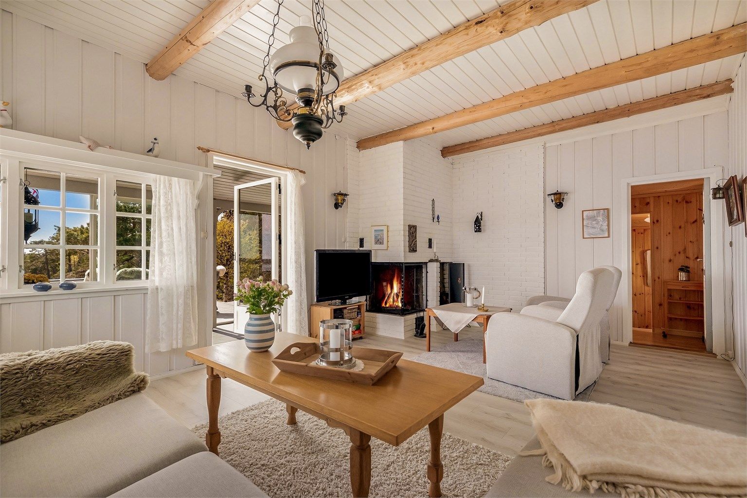 Stuen har rikelig med plass til både sofagruppe og en lesekrok ved peisen.