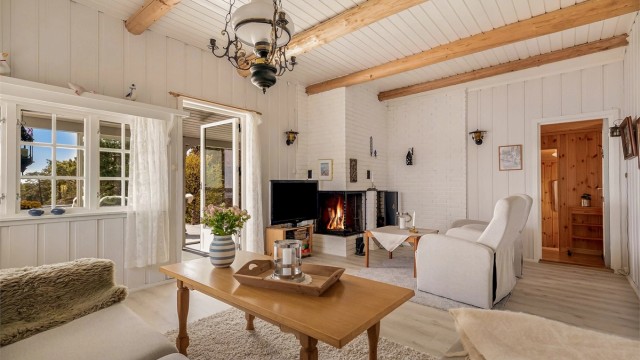 Stuen har rikelig med plass til både sofagruppe og en lesekrok ved peisen.