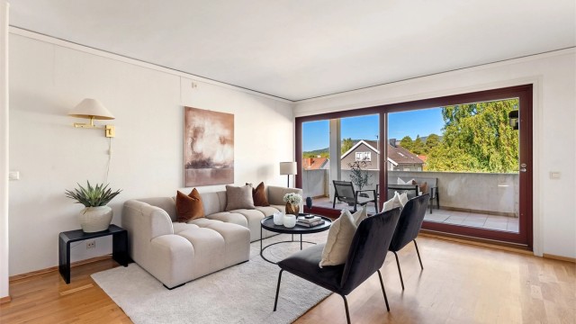 Stuen har god plass til sofagruppe og utgang til en romslig balkong på 12 m².