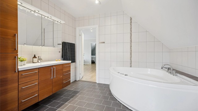 Lekkert flislagt bad i 2. etasje med massasjebadekar, dusjnisje med regndusj og rikelig med baderomsinnredning.