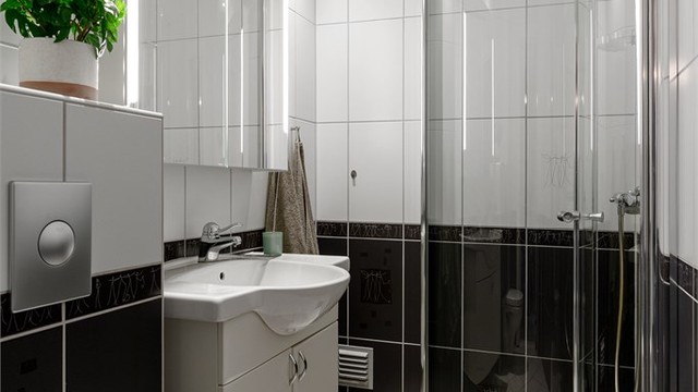 Videre har badet vegghengt klosett og et dusjhjørne med svingbare glassdører.