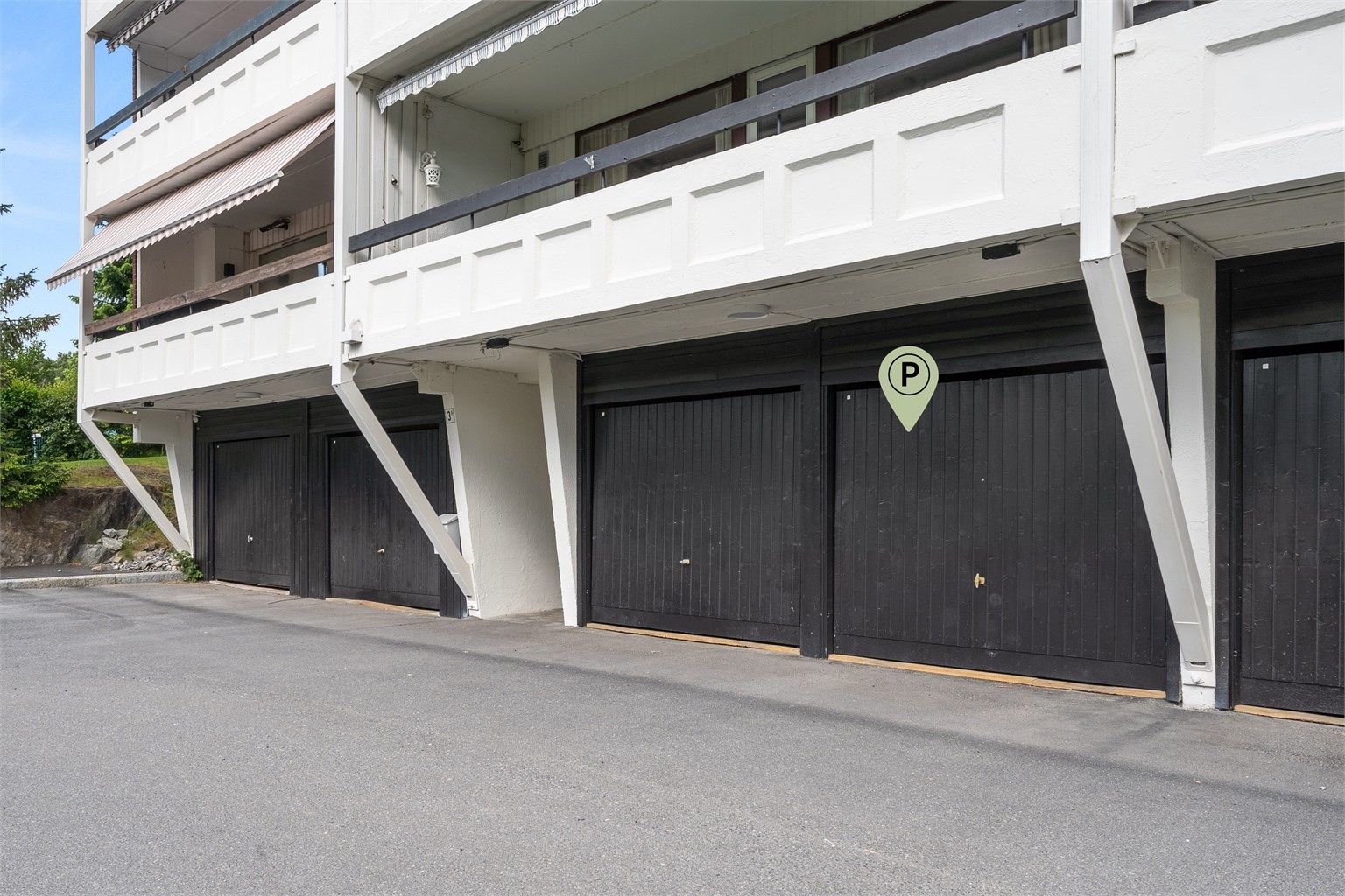 Garasje med elbil-lader ved blokkens inngangspartier - forøvrig god plass til gjesteparkering på sameiets tomt