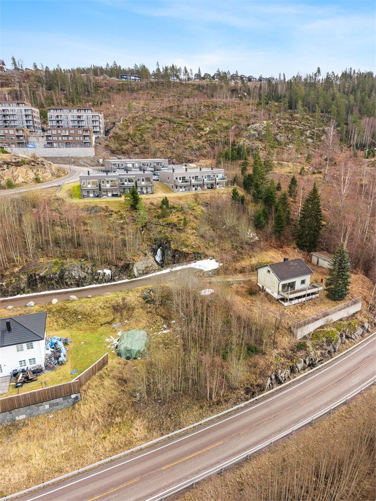 Tomten ligger i skrånende terreng i et etablert boligområde.
Foto: Svein Michaelsen.