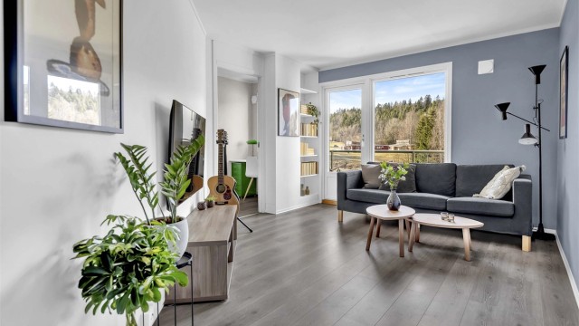 En romslig og gjennomgående leilighet med en praktisk planløsning, beliggende i boligens andre etasje.