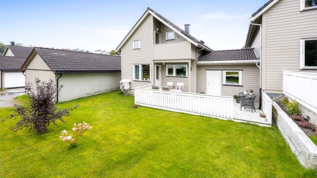 Kjedet enebolig over tre plan med store terrasser, carport og hage mot grønne fellesarealer.
Foto: Espen Edin Døhlen