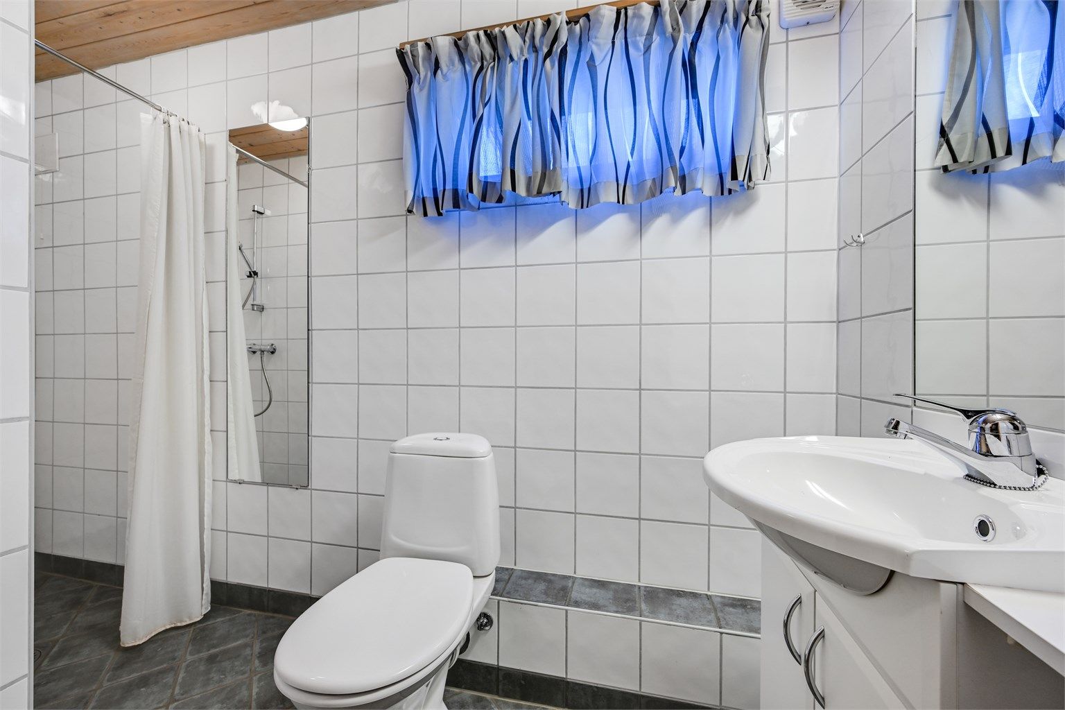 Lyst og praktisk baderom med flislagte overflater og god plass rundt både dusj og innredning. 