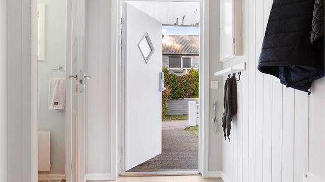Entrédøren har glassfelt og elektronisk kodelås.