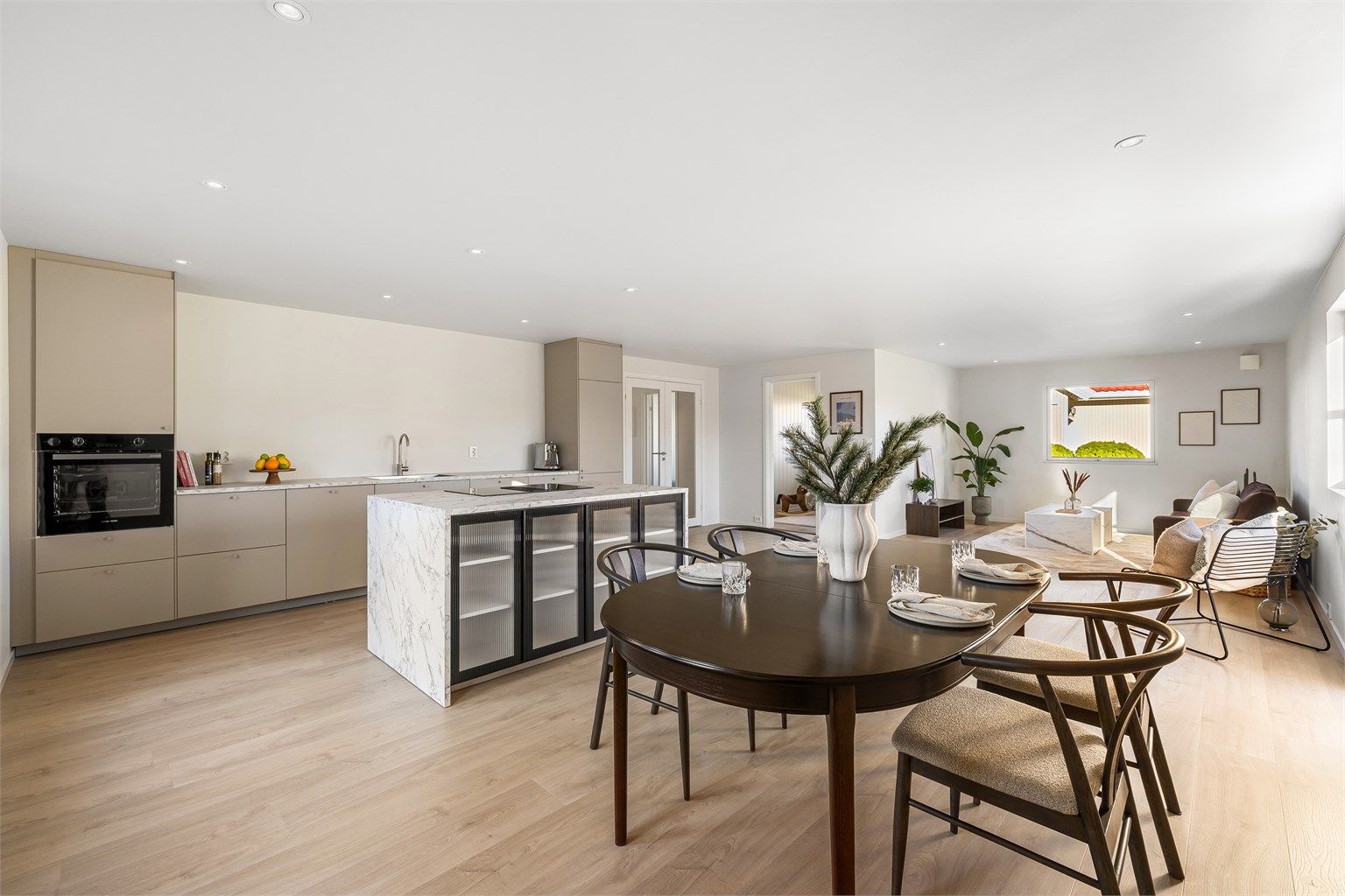 Stue, spisestue og kjøkken er sømløst knyttet sammen i en åpen sosial sone - den kanskje fremste attraksjonen i boligens nye romløsning.