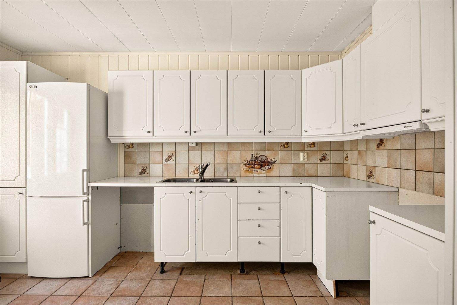 Kjøkkeninnredning med profilerte fronter og laminert benkeplate.