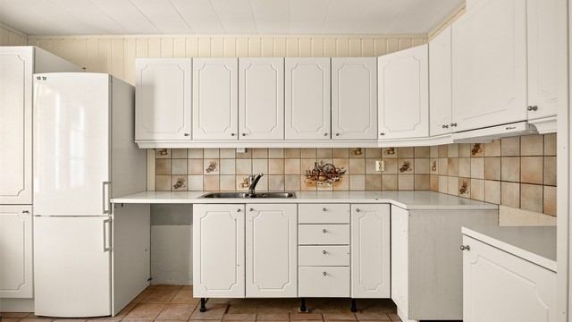 Kjøkkeninnredning med profilerte fronter og laminert benkeplate.