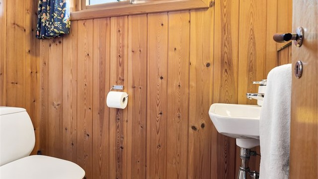 Separat toalettrom i 1. etasje. Vegghengt servant og gulvstående toalett.