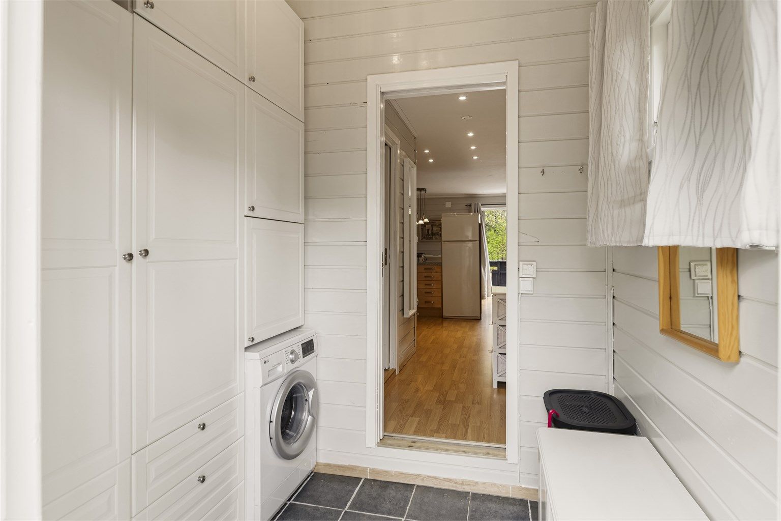 Praktisk entrè med mye skapplass og integrert vaskemaskin. Downlights med trinnløs dimming gir god belysning.