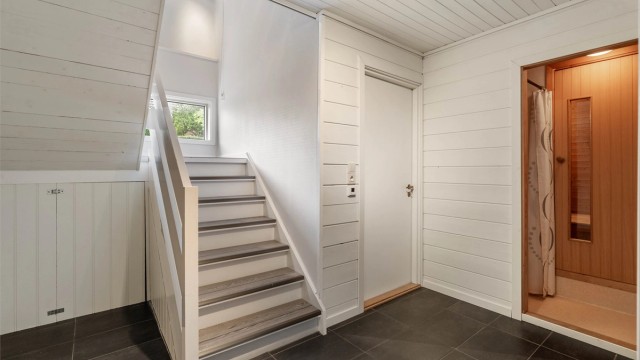 Trappenedgang til underetasjen, som inneholder boder, hobbyrom, badstu og kjølerom.