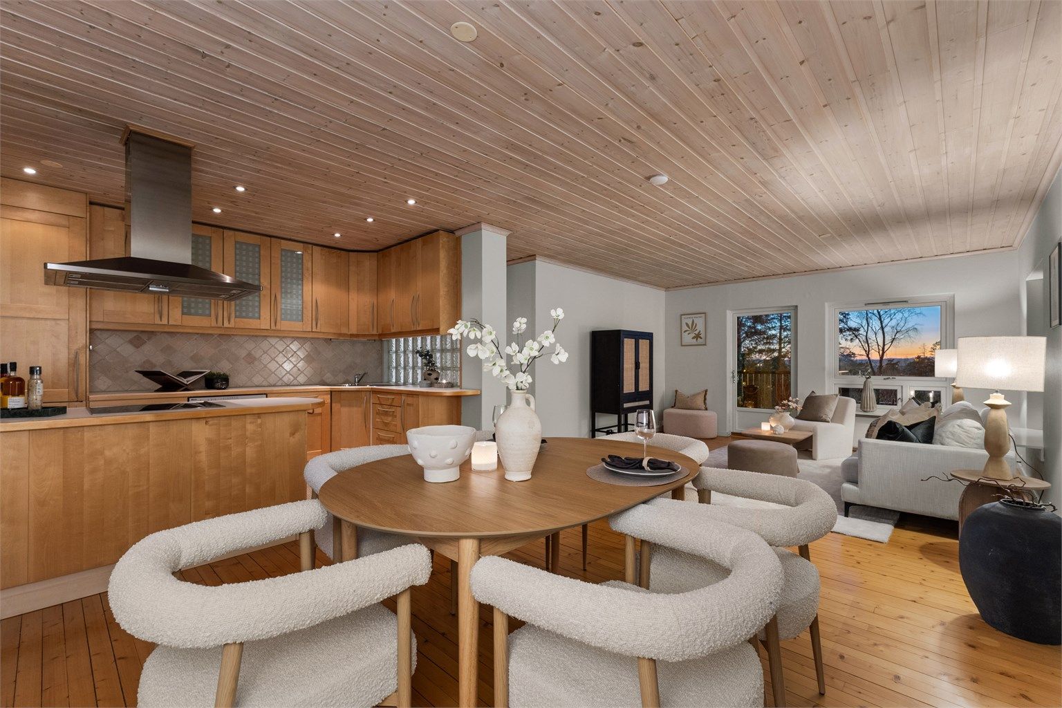 Lys og romslig stue/spisestue med delvis åpen kjøkkenløsning, som passer for både hverdagsliv og sosiale sammenkomster