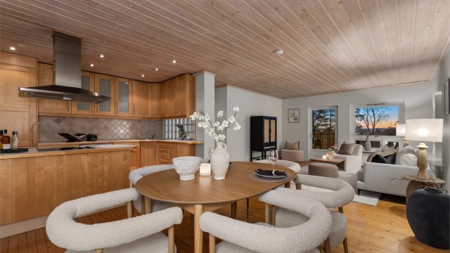 Lys og romslig stue/spisestue med delvis åpen kjøkkenløsning, som passer for både hverdagsliv og sosiale sammenkomster