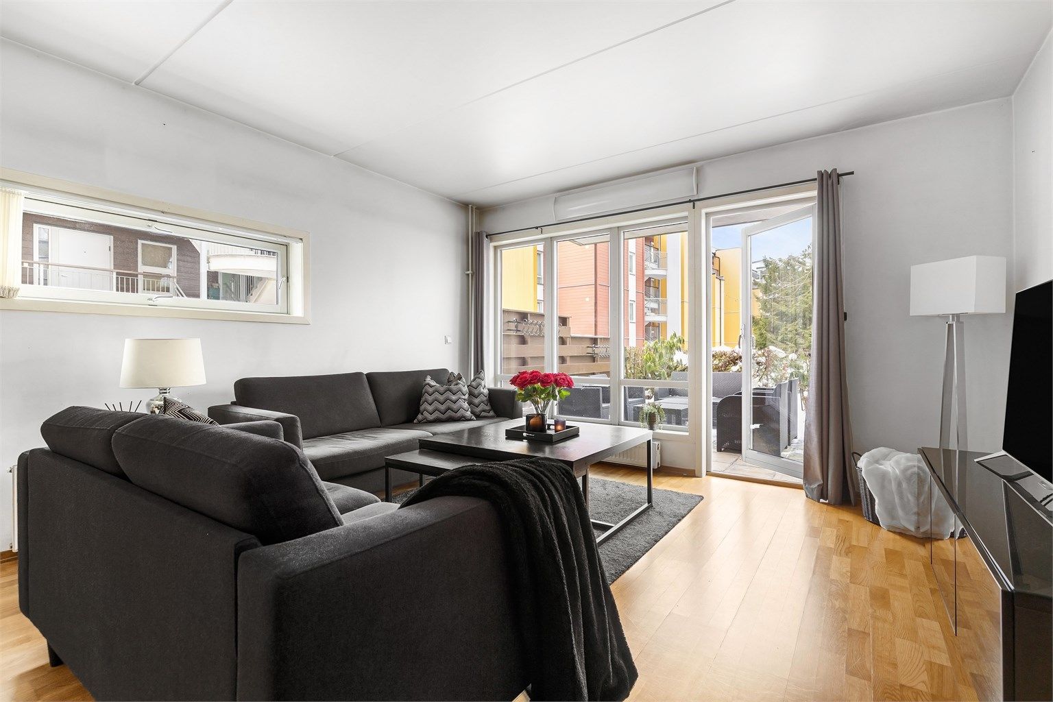 Leiligheten har en romslig stue med vindusflater på flere kanter som sørger for at det kommer mye naturlig lys inn i boligen