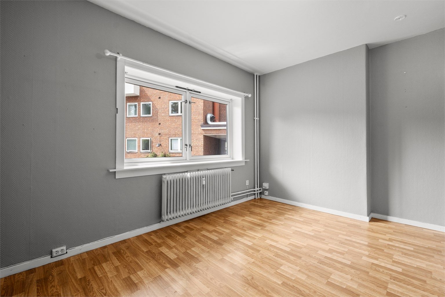 Lys og romslig stue med god plass til sofagruppe og tv-møblement.