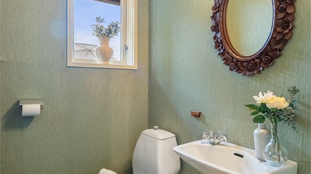 Praktisk, separat toalettrom i tilknytning til gangen, utstyrt med servant og toalett.