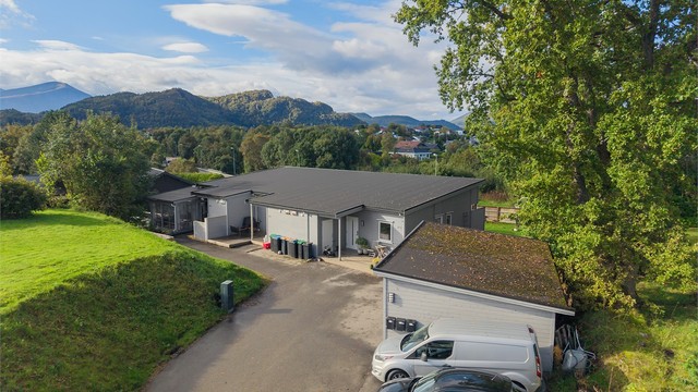 Dronebilde av fasade og felles carport og parkeringsplasser