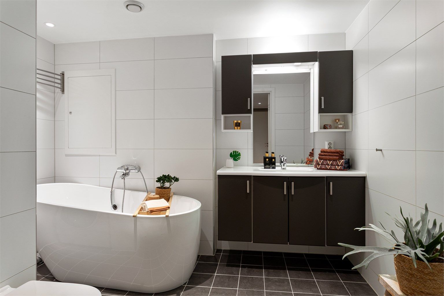 Bad 1: Flislagt bad med gulvvarme. Downlights i himlingen. Innredet med vegghengt servantinnredning, vegghengt toalett, speil med overlys og badekar.