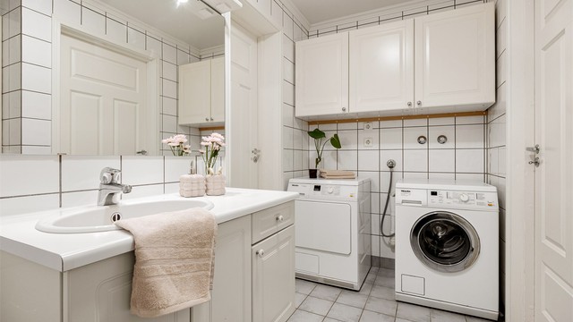 Badet har servantinnredning, speil med overlys og opplegg for vaskemaskin.