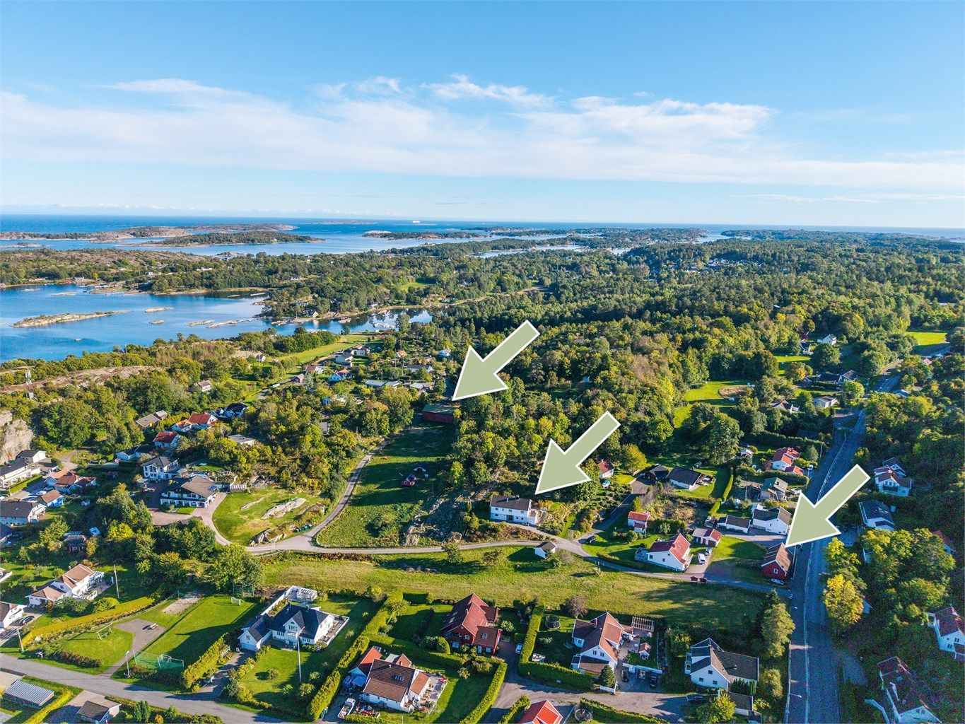 Luftig overblikk over Grimestad med den karakteristiske skjærgården i bakgrunnen. Eiendommen består av hovedhus, garasje, lagerhall og låve.