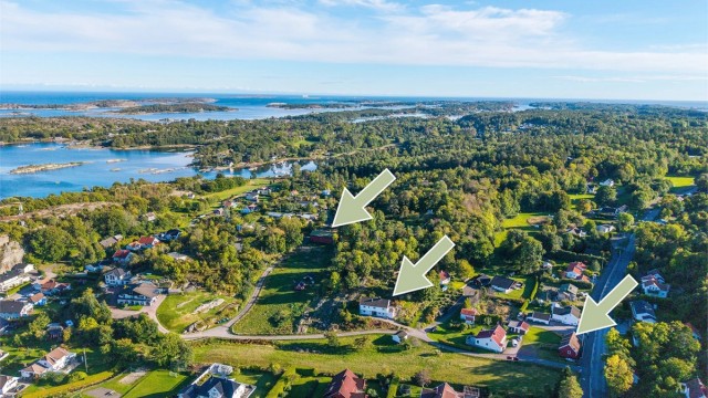 Luftig overblikk over Grimestad med den karakteristiske skjærgården i bakgrunnen. Eiendommen består av hovedhus, garasje, lagerhall og låve.