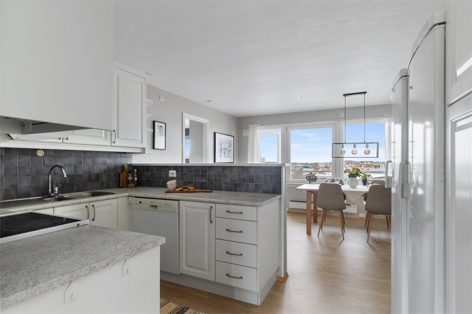 Kjøkkenet har en delvis åpen løsning mot spisestuen, som gir en sosial og luftig sone for måltider.