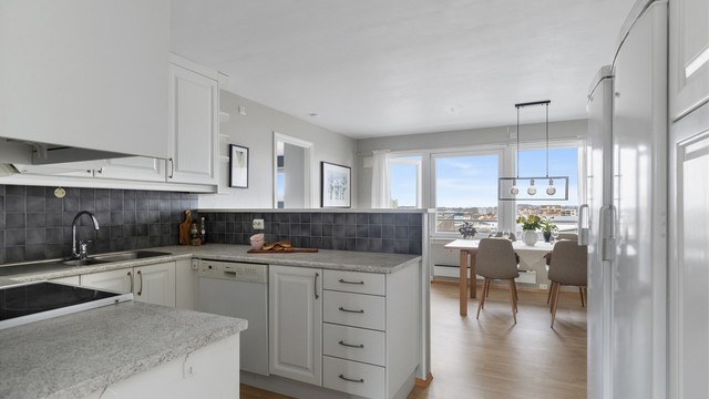 Kjøkkenet har en delvis åpen løsning mot spisestuen, som gir en sosial og luftig sone for måltider.