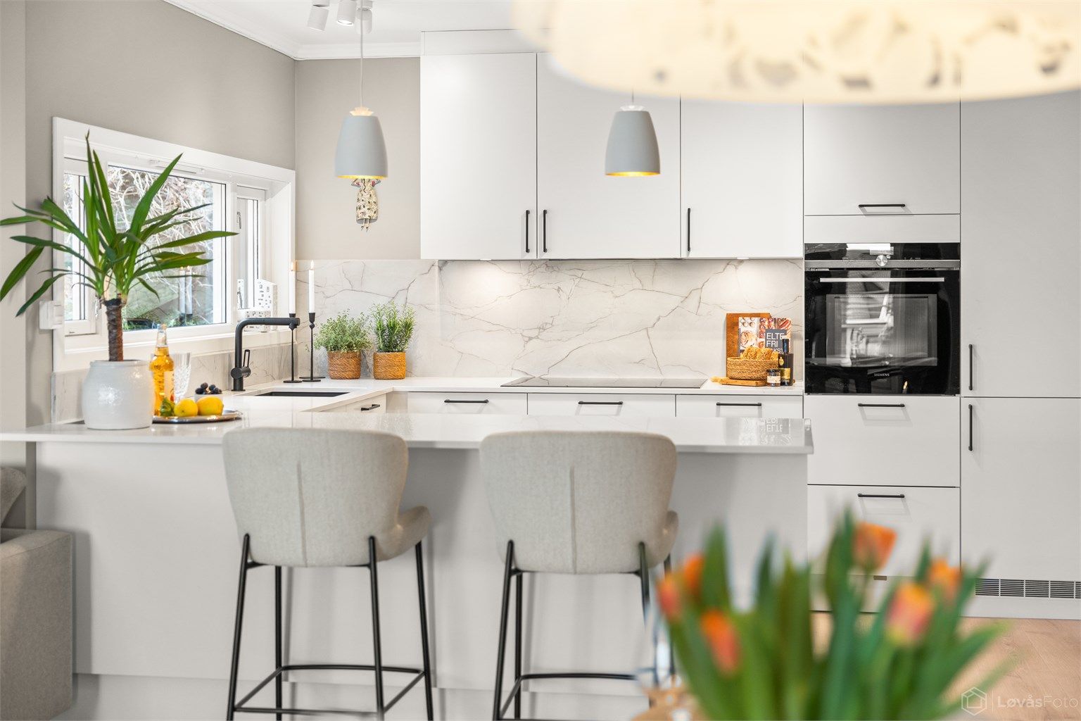 Kjøkkeninnredning fra 2022 med benkeplate i stein og integrerte hvitevarer.