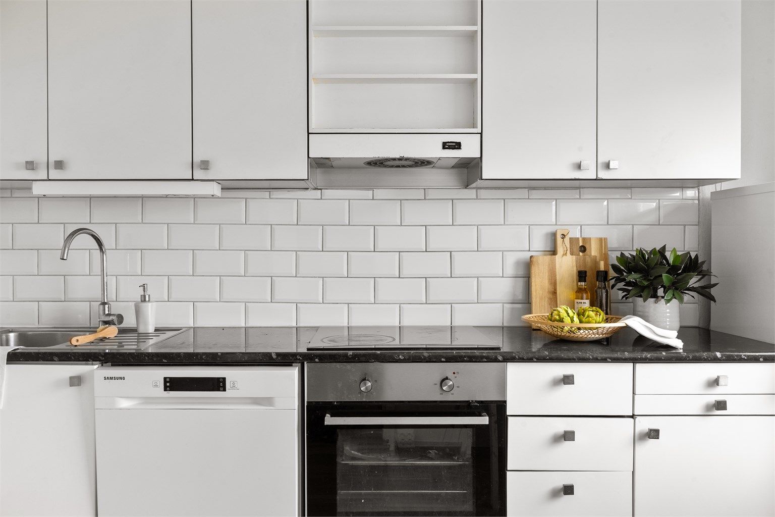 Kjøkkeninnredning i tidløst hvitt  og mørk benkeplate. 