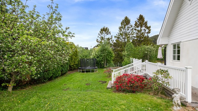 Hagen er pent opparbeidet med plen og beplantning, og gir gode lekemuligheter.