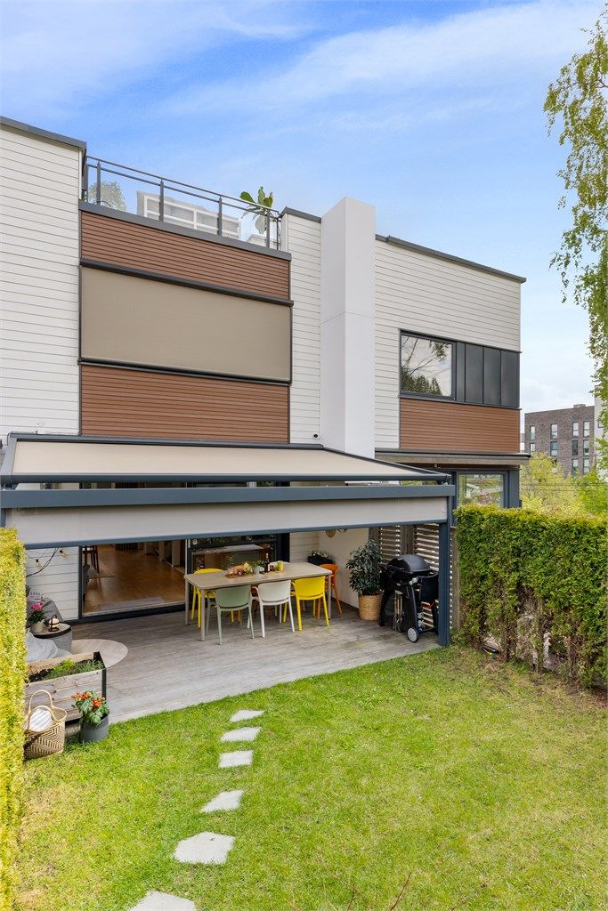 Pergolaen beskytter både mot sol, regn og vind og gir en fleksibel bruk av uteområdene.