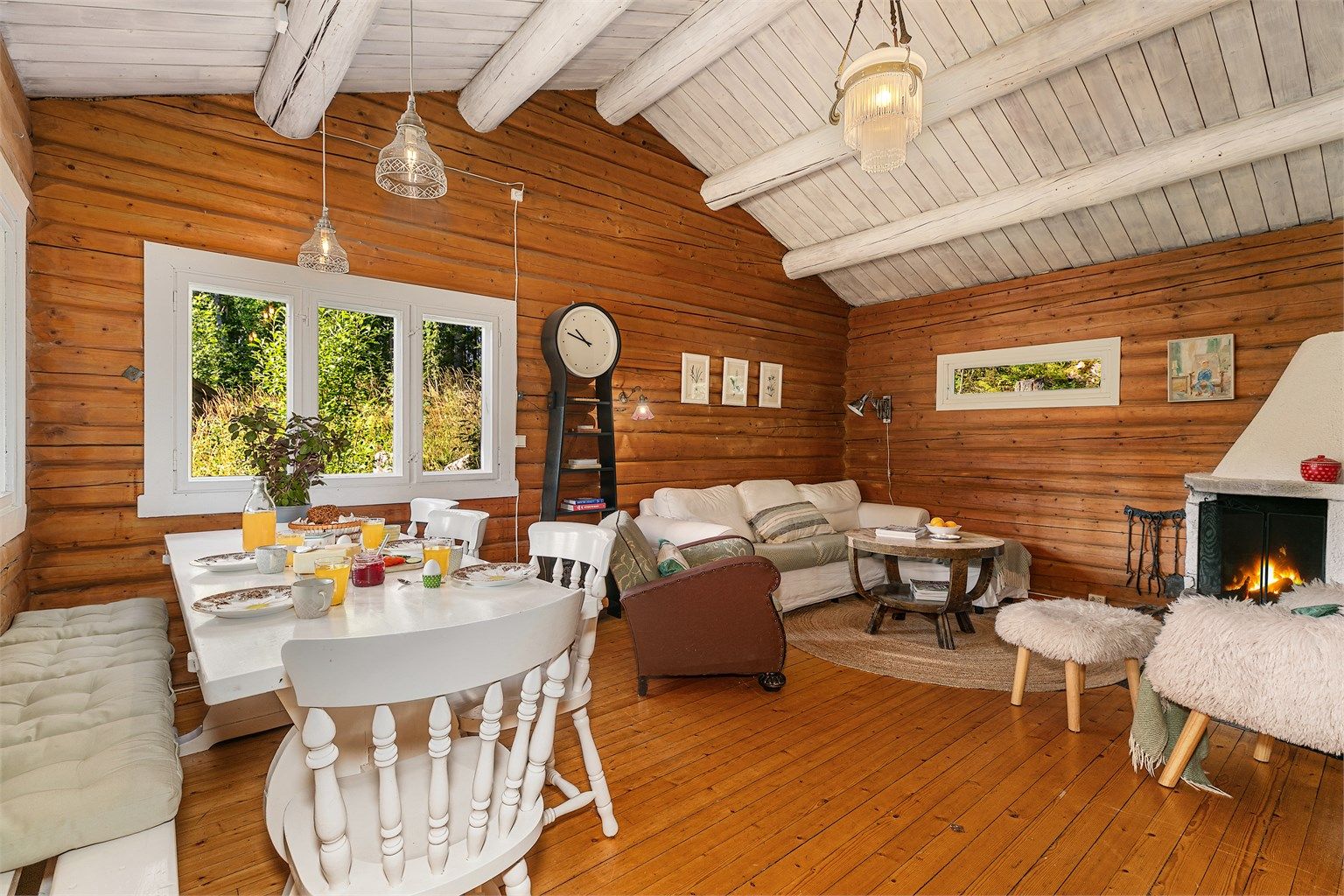 Romslig stue med peis, god takhøyde og plass til spisebord – perfekt for hyggelige middager og late kvelder foran peisen