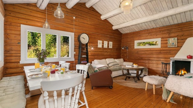 Romslig stue med peis, god takhøyde og plass til spisebord – perfekt for hyggelige middager og late kvelder foran peisen