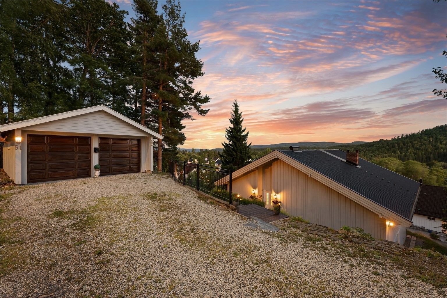Eiendommen ligger høyt og fritt til, med dobbelgarasje og gruset gårdsplass. Foto: Zovenfra.no