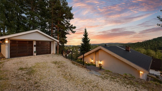 Eiendommen ligger høyt og fritt til, med dobbelgarasje og gruset gårdsplass. Foto: Zovenfra.no