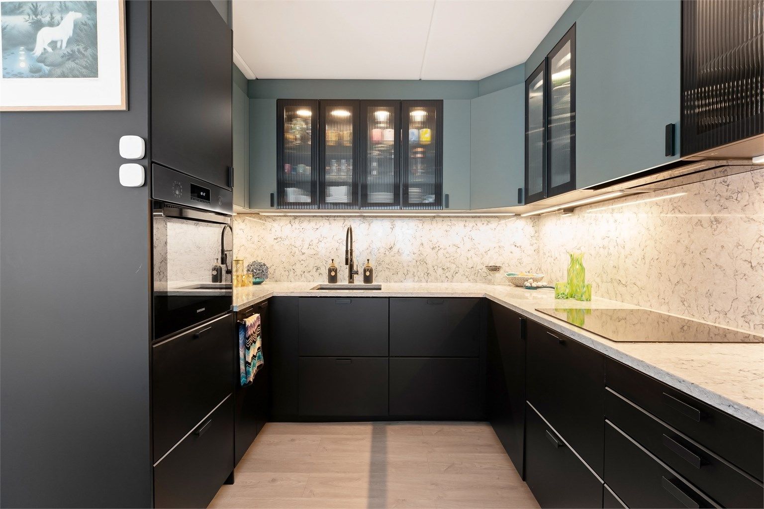 Kjøkkenet har integrerte hvitevarer, samt frittstående kjøleskap med fryser