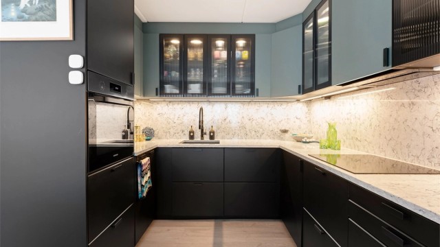 Kjøkkenet har integrerte hvitevarer, samt frittstående kjøleskap med fryser